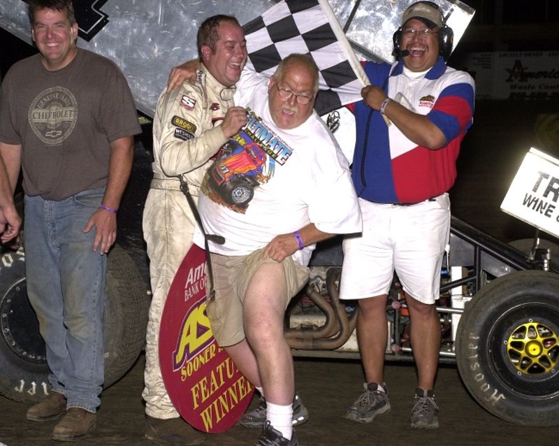 Mike McClelland shows a little leg in American Bank of Oklahoma ASCS Sooner Region victory lane after his son, Sean McClelland, rallied from the ninth row to make a last corner pass for the win in Saturday night's 25-lap feature at Creek County Speedway